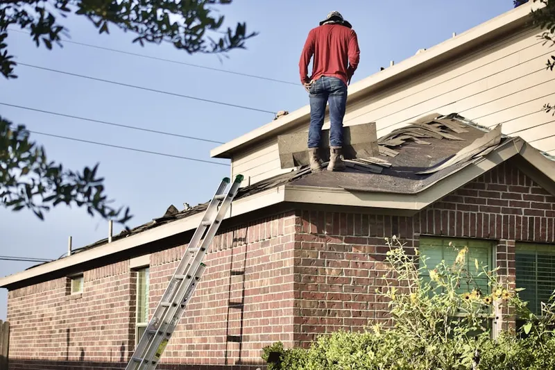 Professional roofer working on a residential roof in Burning Bush